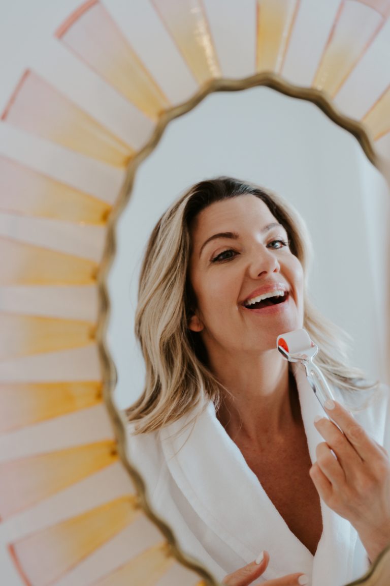 woman facial sculpting in mirror