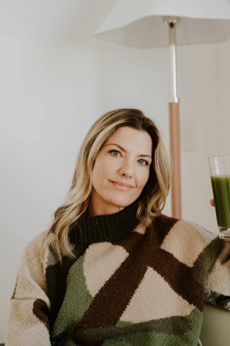 woman smiling drinking green smoothie