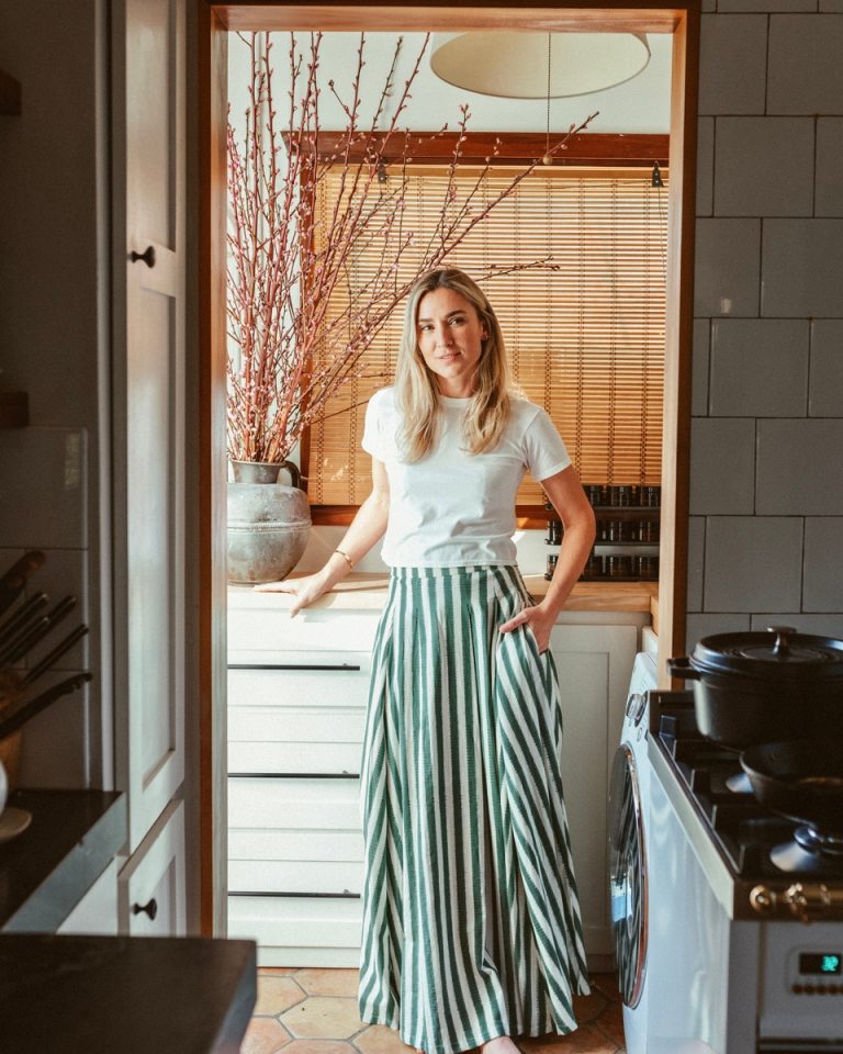 Woman standing in kitchen with practical housewarming gift