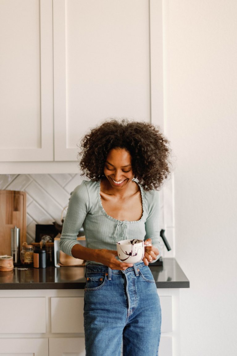 Woman drinking coffee in the kitchen Best hair styling products