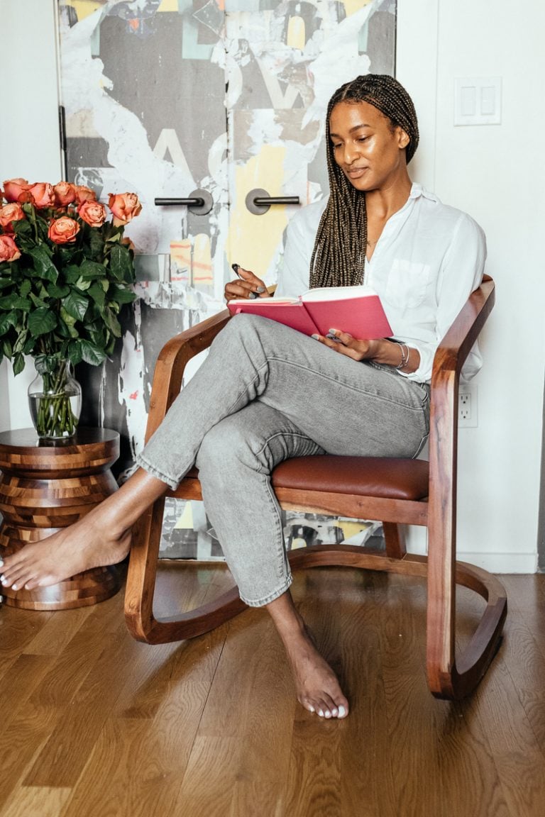 Shanika Hillocks reading in her living room chair 2023