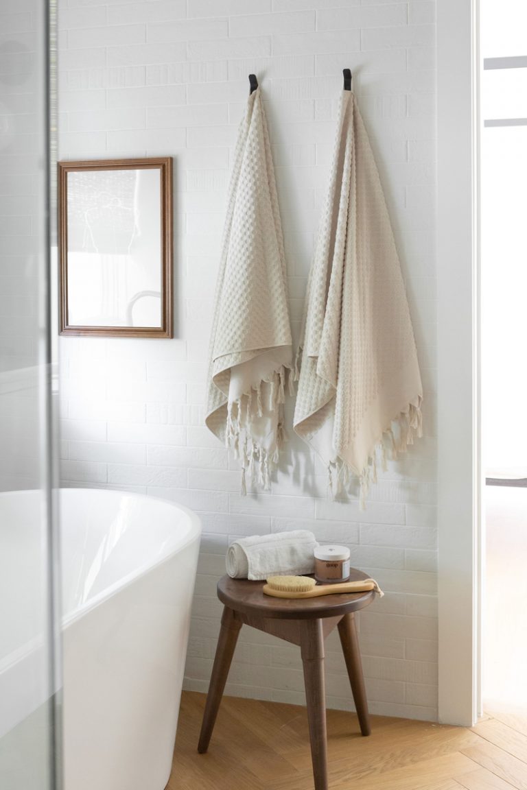 Bath towels and products in white bathroom.