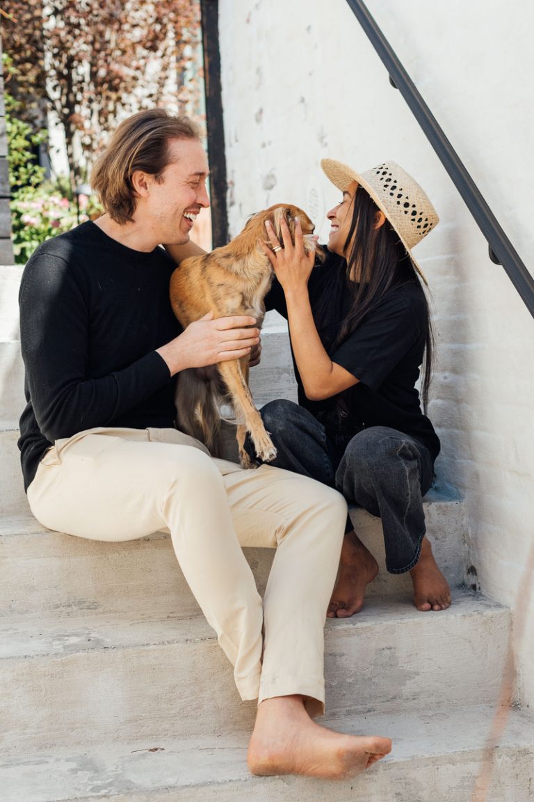 pareja sonriente acariciando perro, signos de terapia de pareja