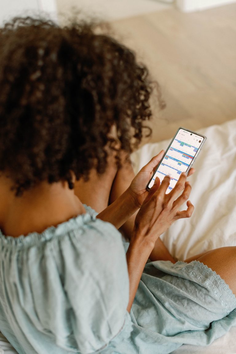 woman using phone, anti-aging hand creams