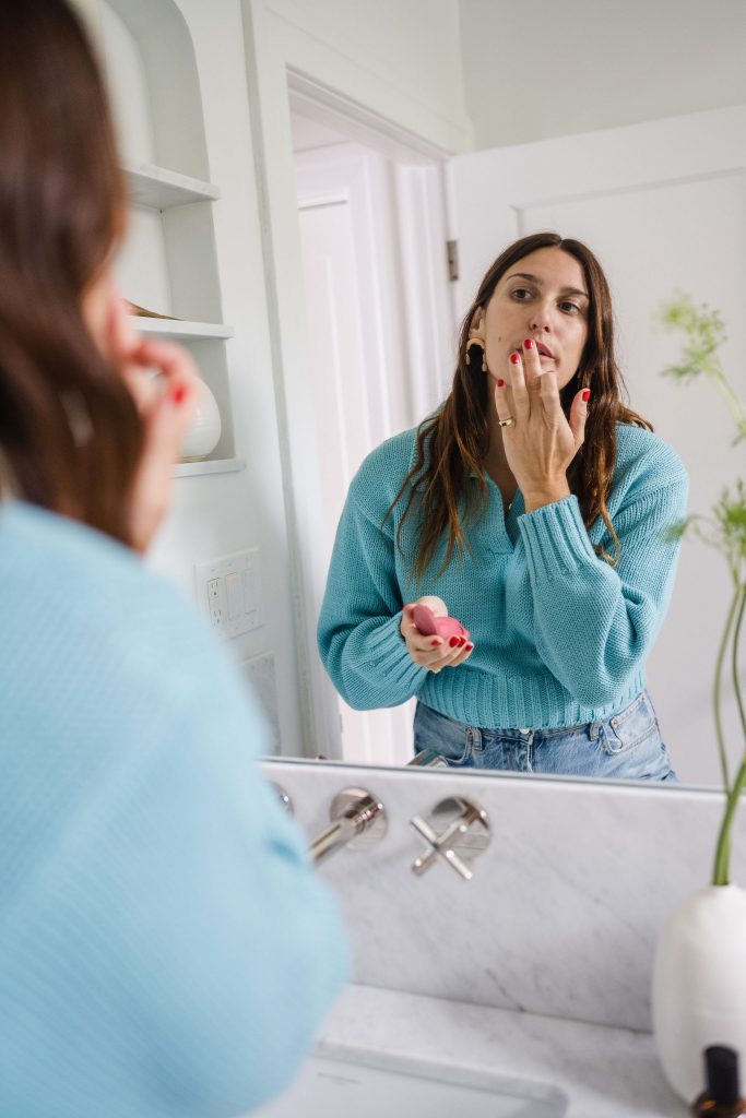 applying lip stain in mirror