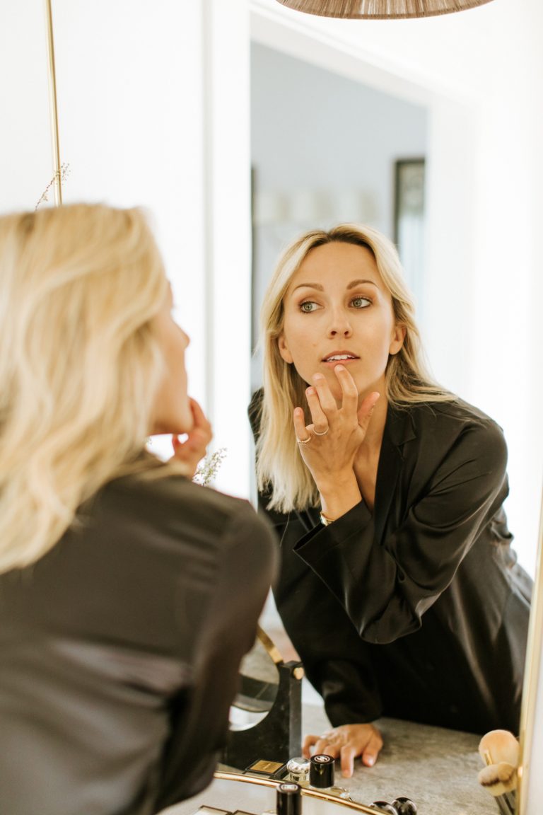 woman applying lip gloss, botox alternatives