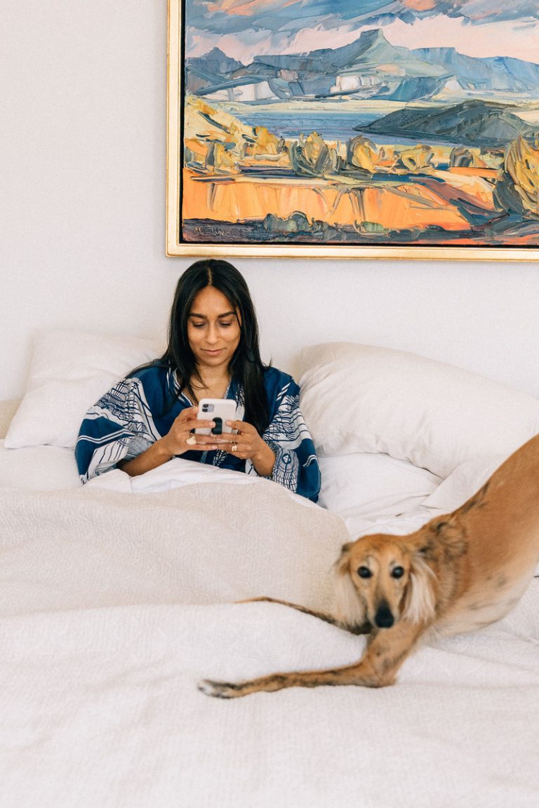 por teléfono en la cama con perro, almohada antiarrugas