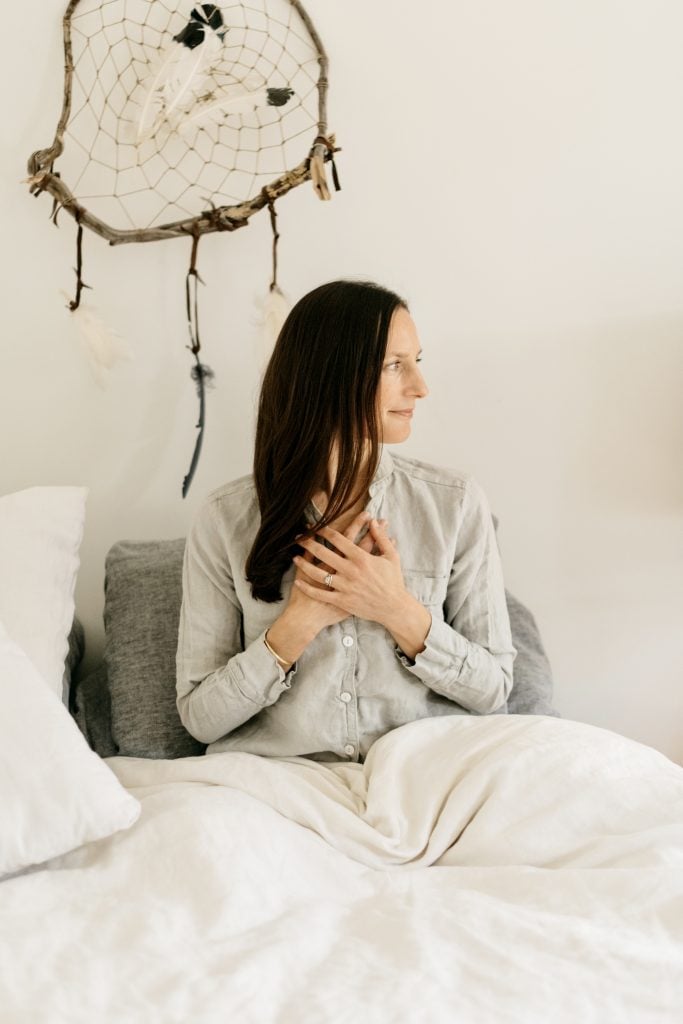 woman meditating in bed, winter selfcare