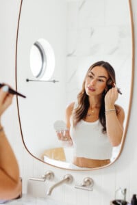 Woman applying makeup.