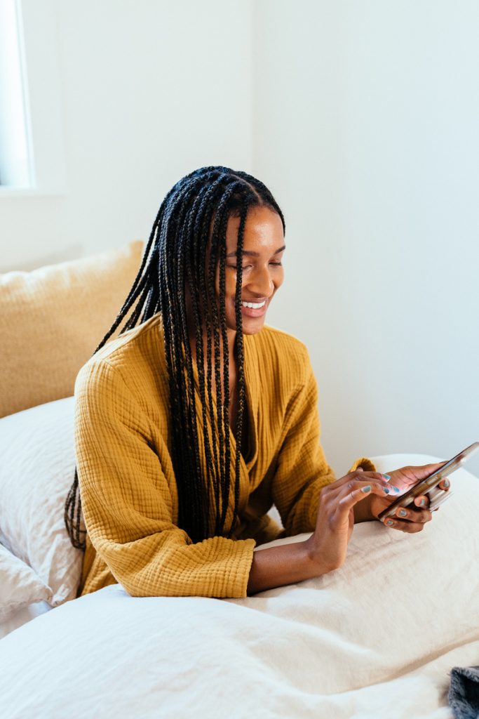 Woman using phone in bed