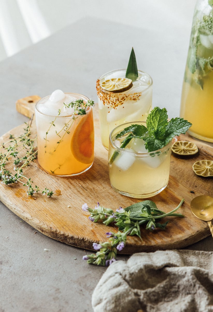 Three kombucha cocktails on a wooden board