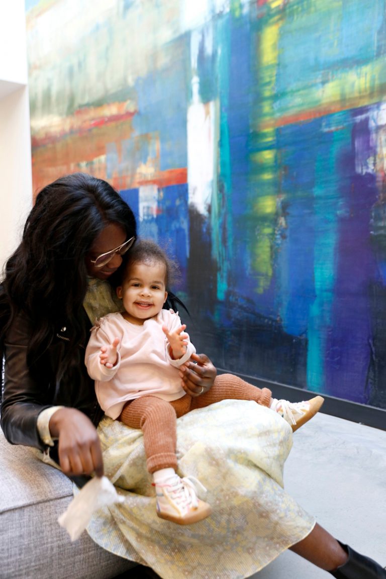 Mother and daughter sitting in front of abstract painting. Friendships after kids.