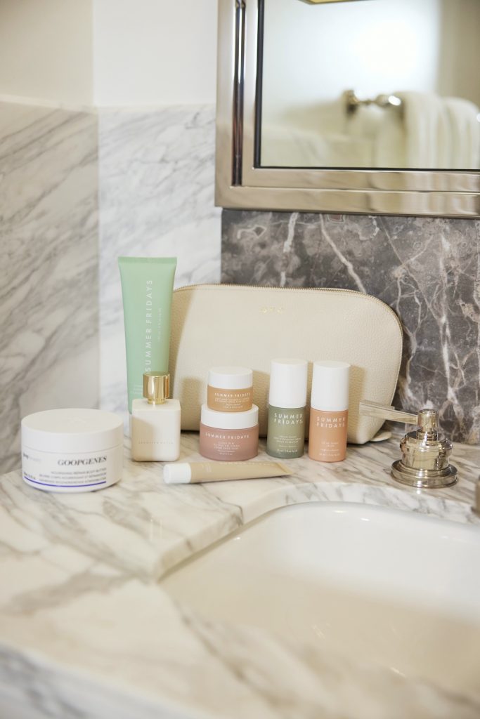 Summer Fridays skincare products on marble bathroom countertop.