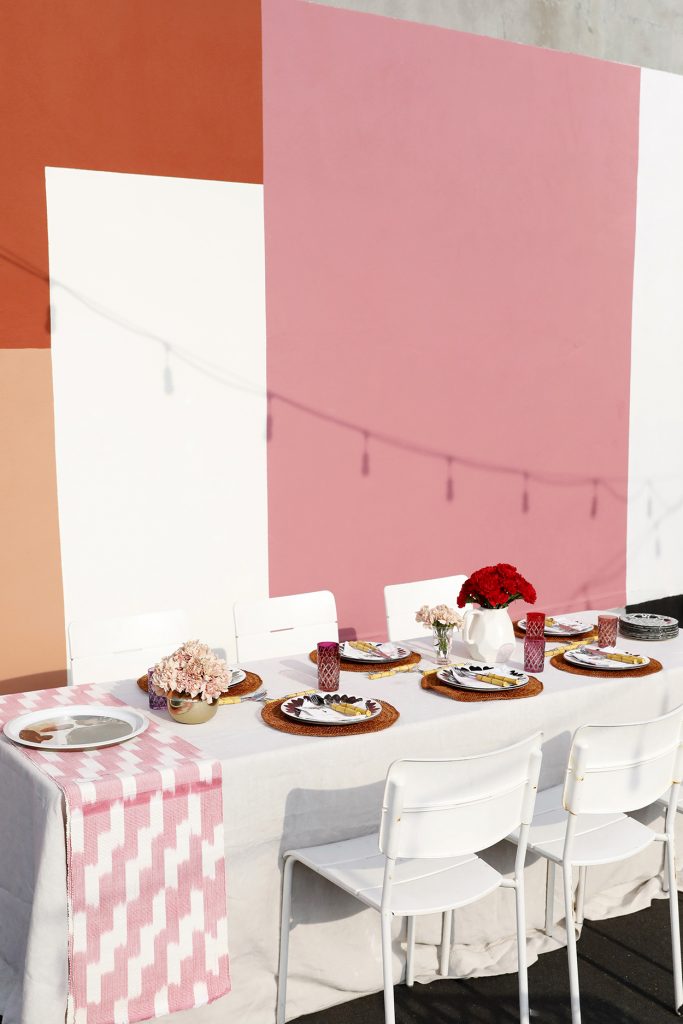 dinner party table decor on a new york city rooftop with white table and pink decor