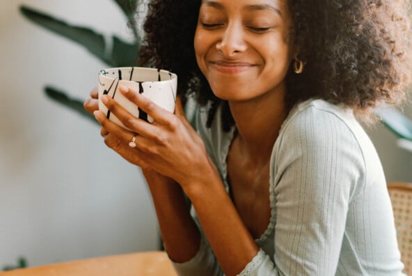 Woman drinking coffee and eating breakfast.