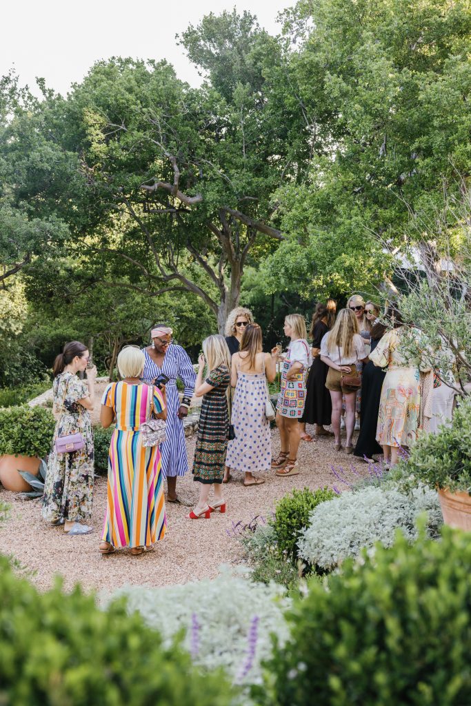 Women mingling at party in backyard.