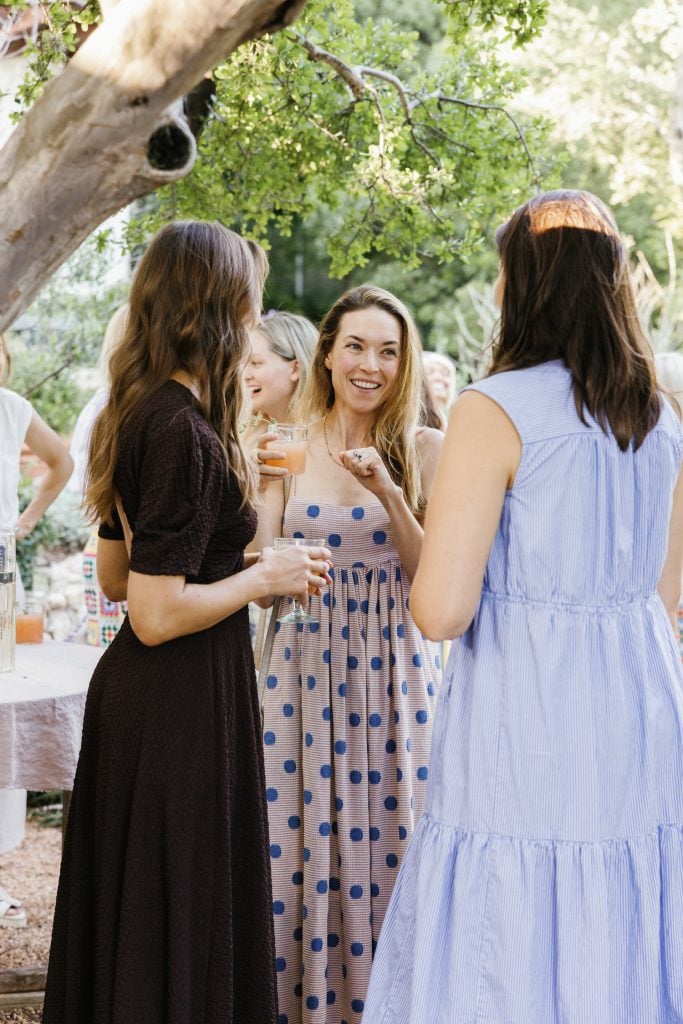 amigos se mezclan en una fiesta de aperitivos en el patio trasero de Camille, Mia Baxter