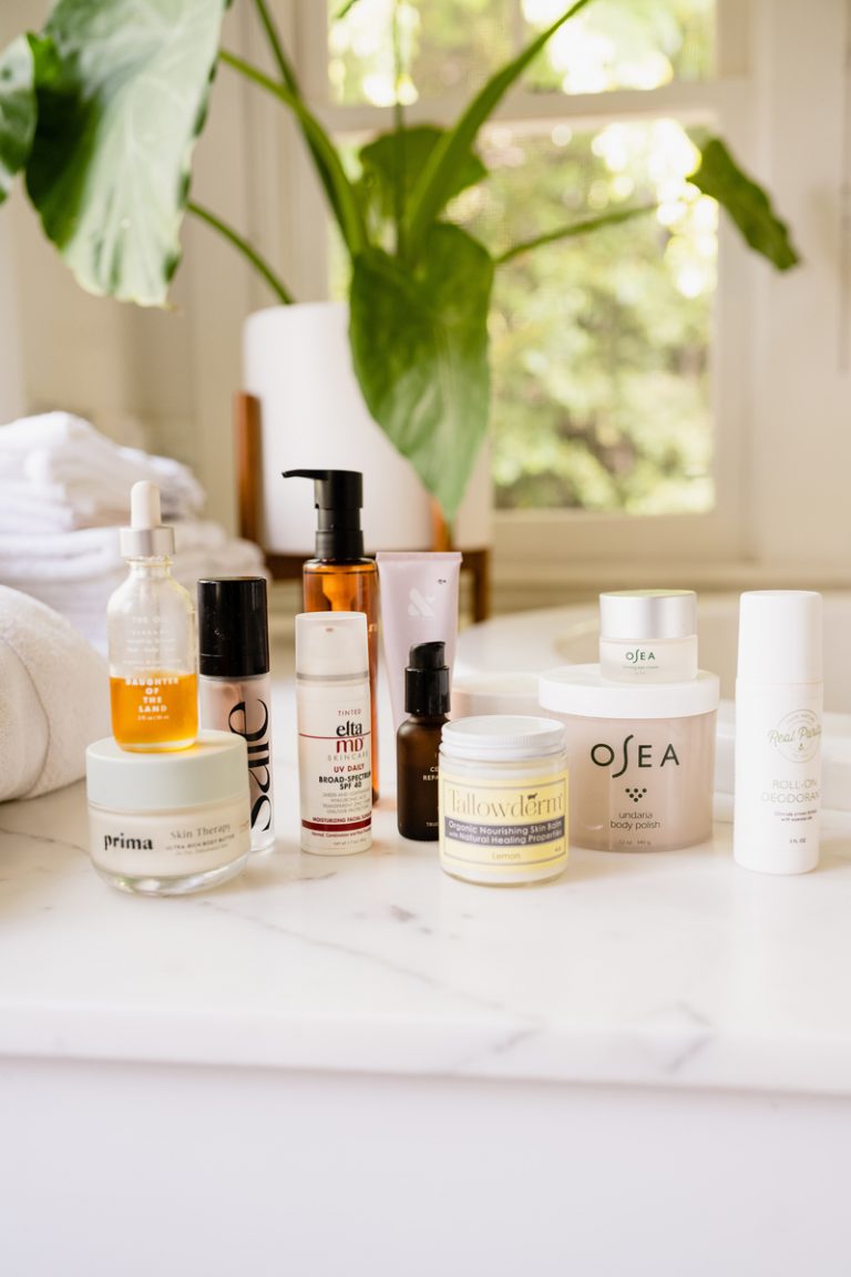 Various skincare products on marble bathroom counter.