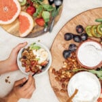 Circle wood serving board with fruits, granola, and Greek yogurt_high fiber breakfast