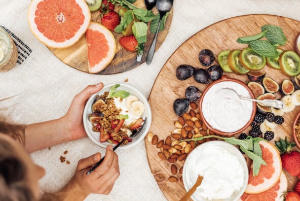 Circle wood serving board with fruits, granola, and Greek yogurt_high fiber breakfast