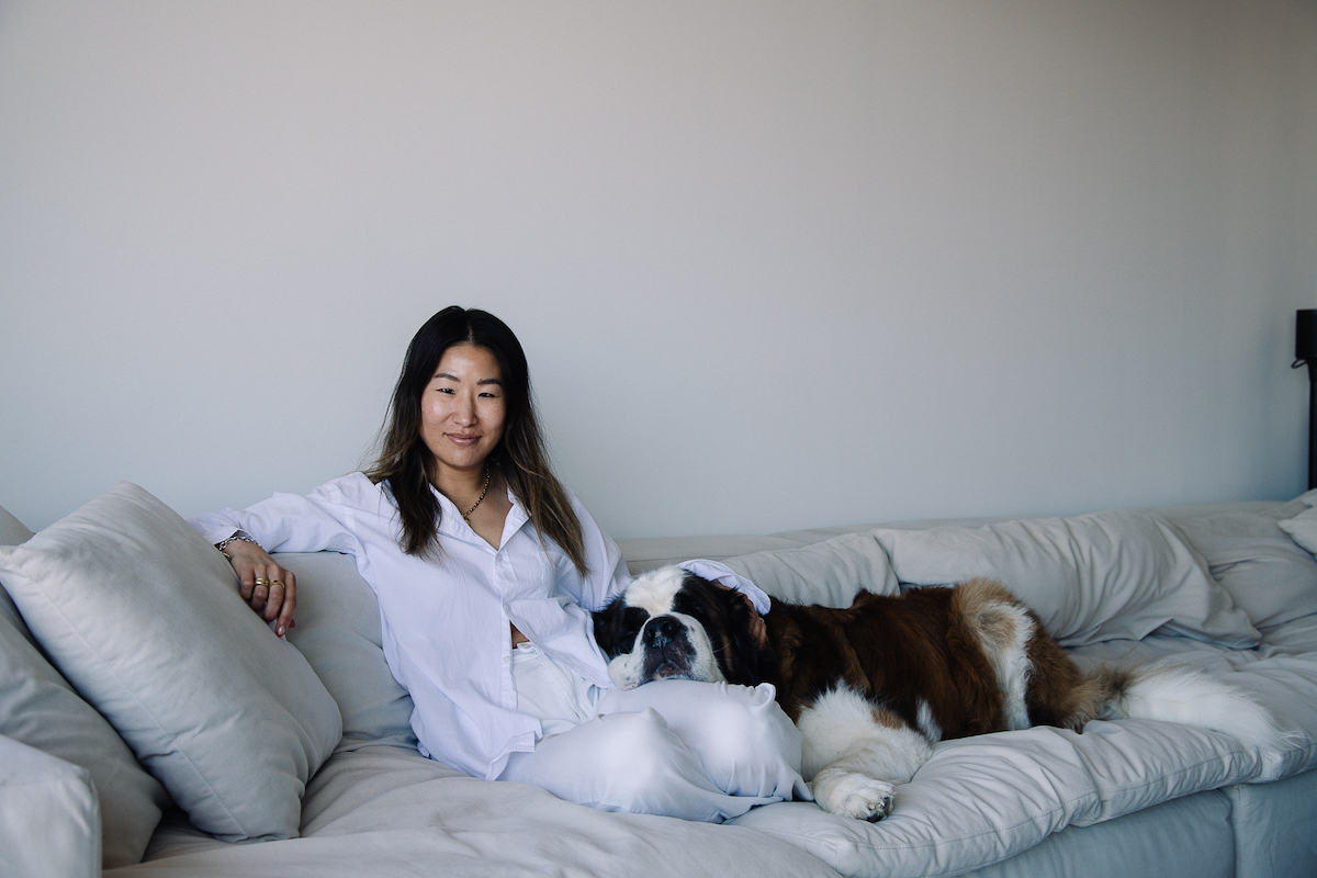 Jenny Yun está sentada en el sofá con un perro.