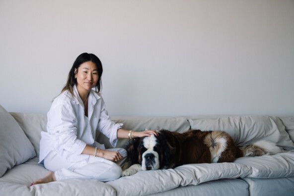 Jennie Yoon sitting on couch with her dog.