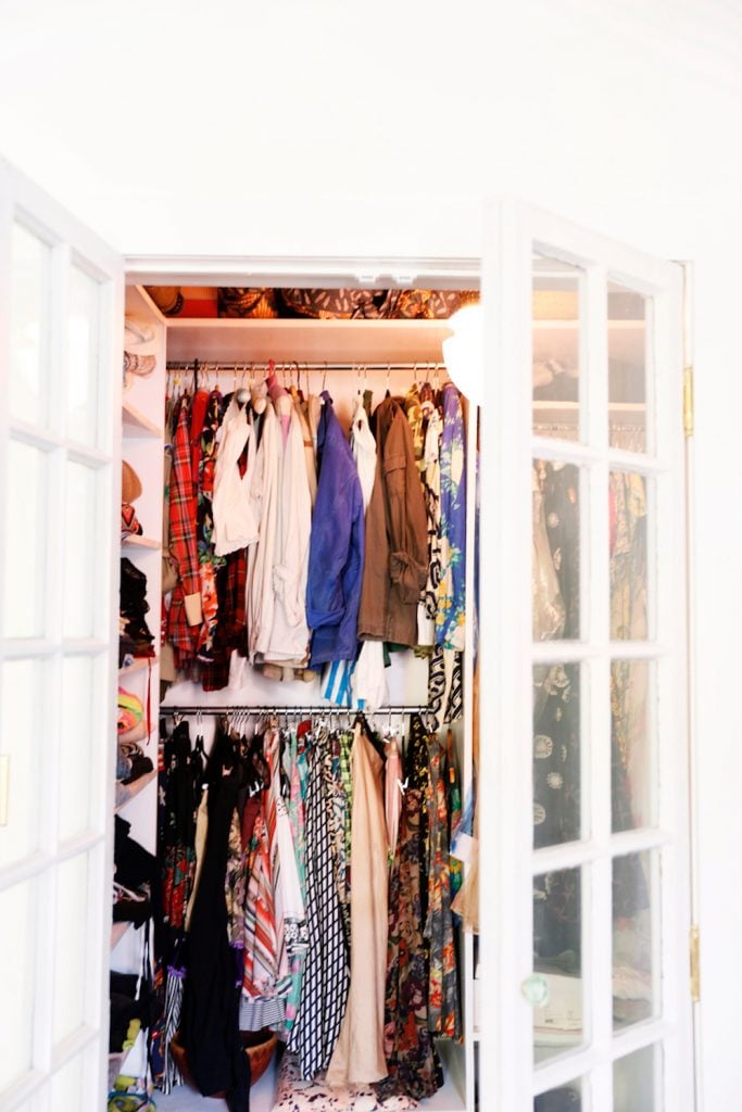 Bright, white closet filled with colorful clothes.