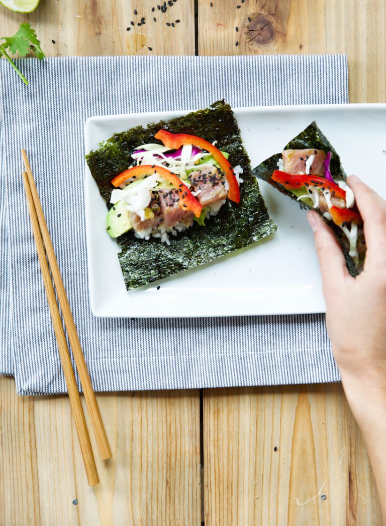 Nori Temaki is served on a white rectangular plate with a white and blue striped tablecloth.