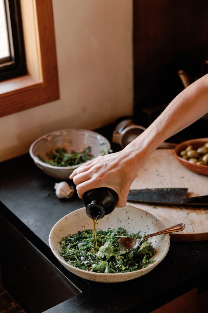 pouring olive oil into Italian salsa verde