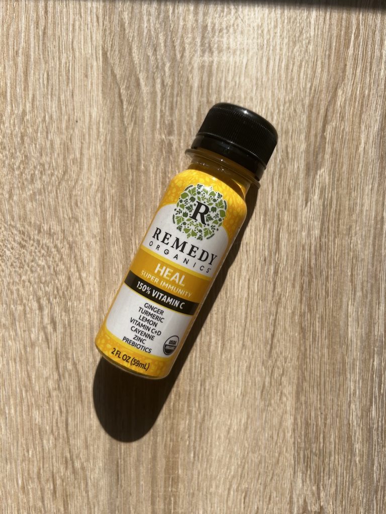 Remedy Organics Heal Super Immunity wellness shots on light wood board.