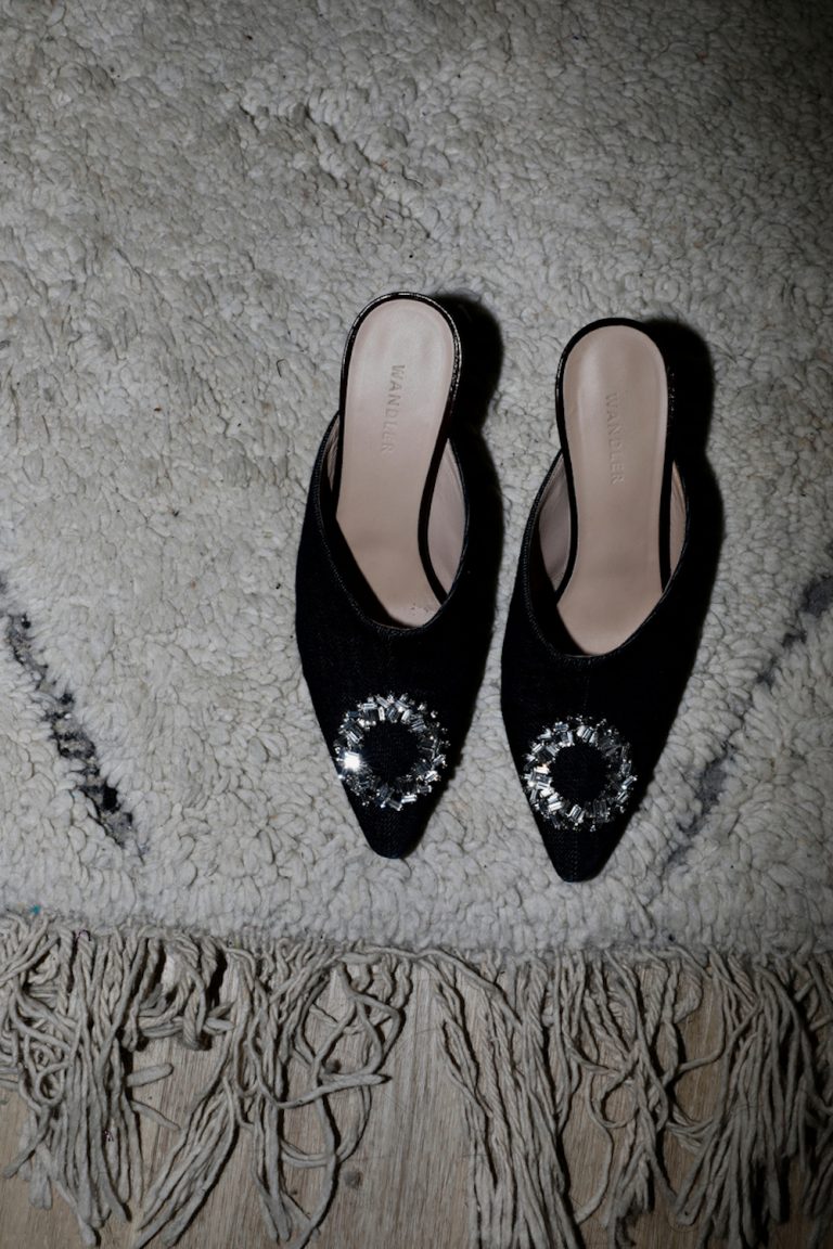 Black jeweled shoes on rug.