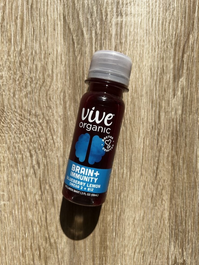 Vive Organic Brain + Immunity wellness shots on light wood board.