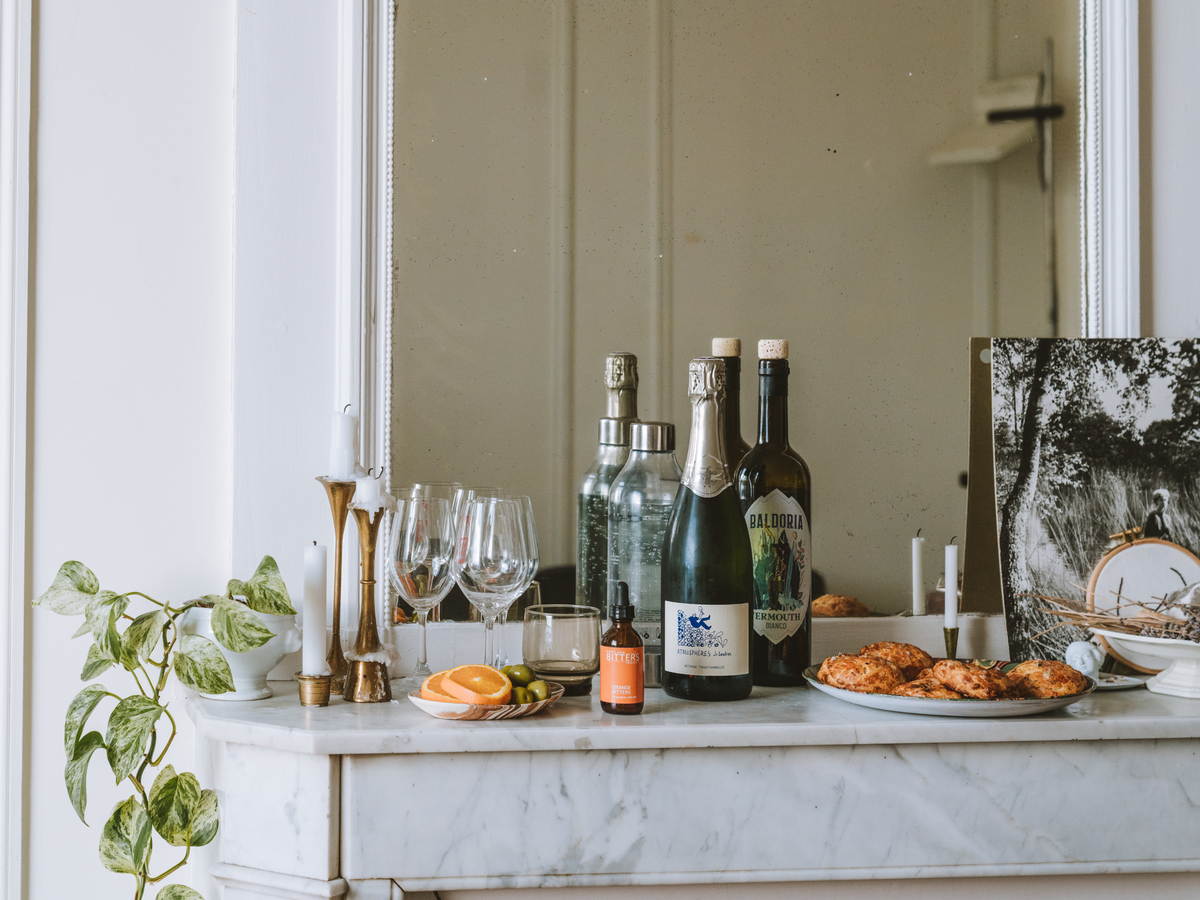 Wine bottles and glaasses on a white marble mantle - Joann Pai Photography