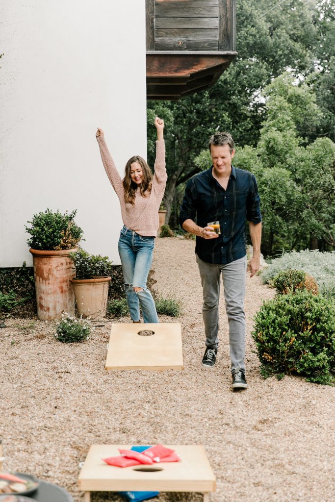 backyard design ideas couple playing cornhole