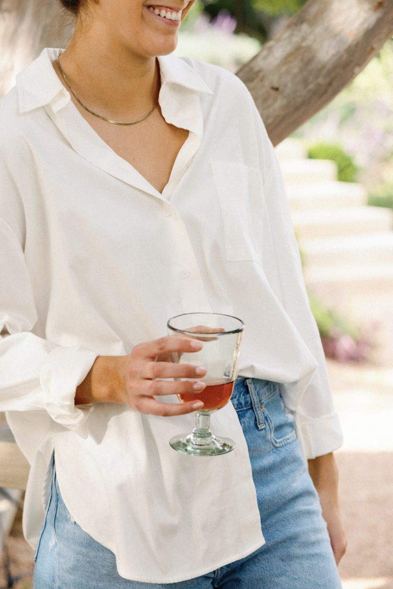 Woman wearing white button-down shirt.