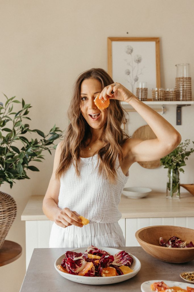 Camille Styles making citrus salad in kitchen.