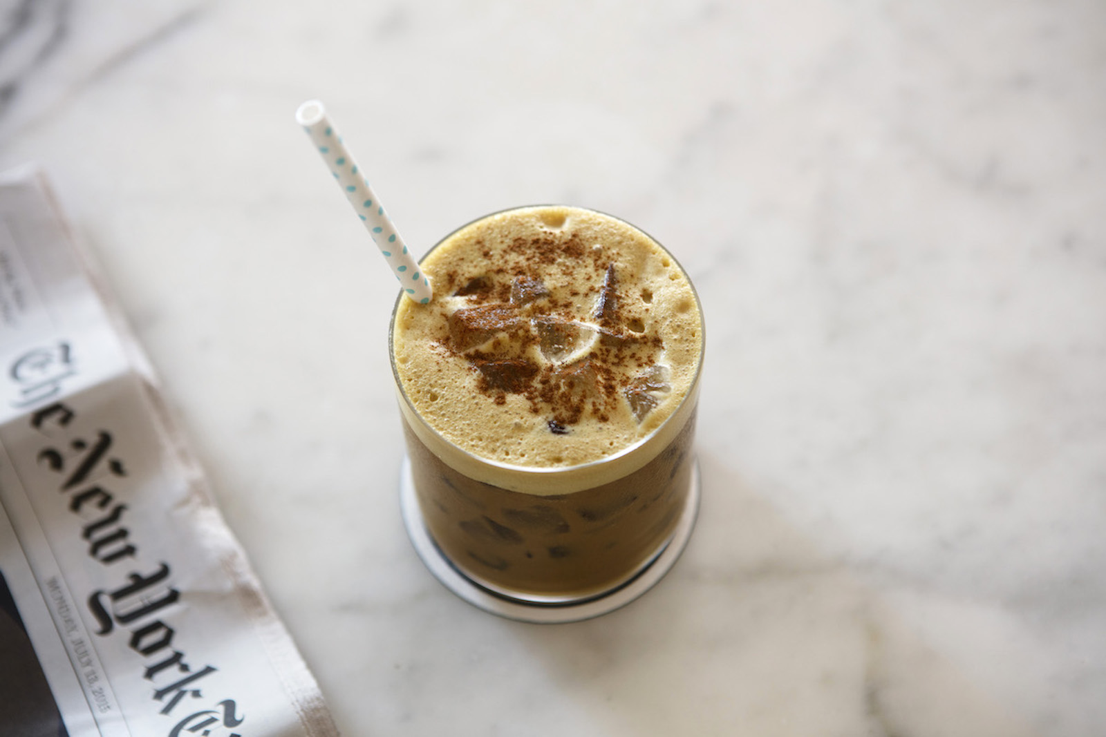 Splash of iced coffee in tall glass and coffee beans. Stock Photo