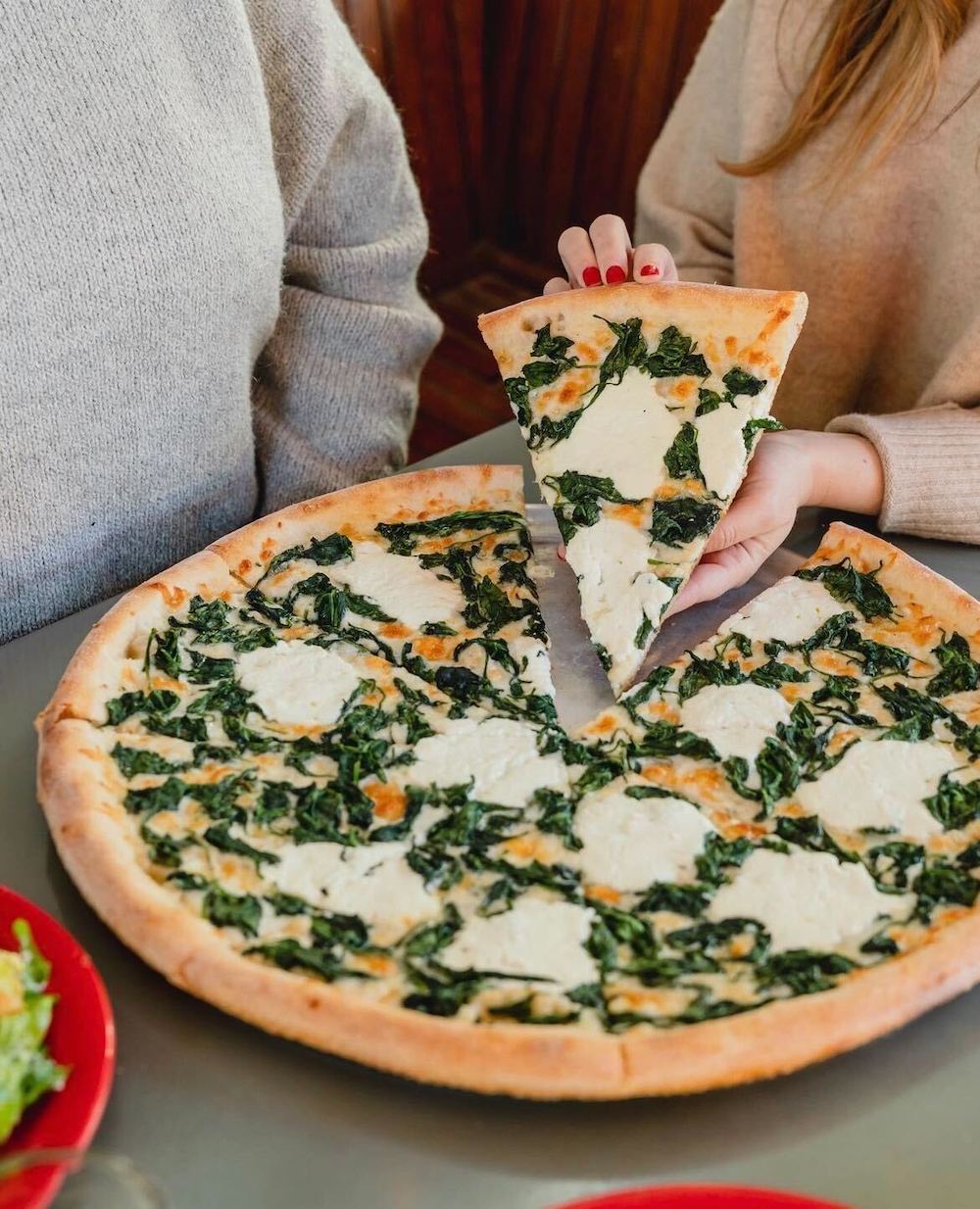 Whole pizza with greens at Home Slice Pizza in Austin, Texas.