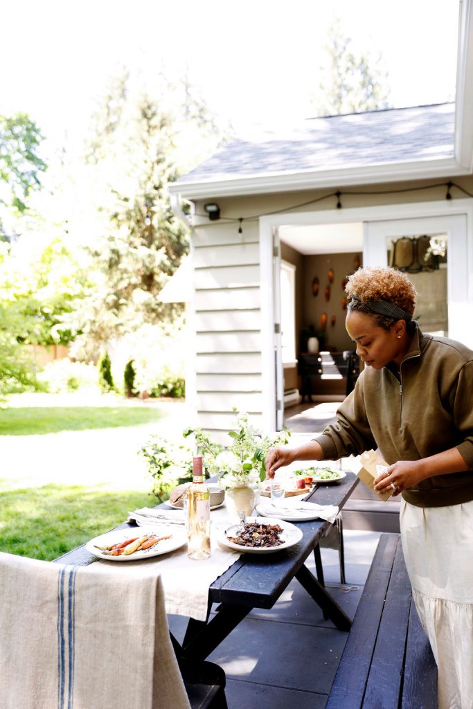 Designer Kennesha Buycks setting outdoor table for summer dinner party.