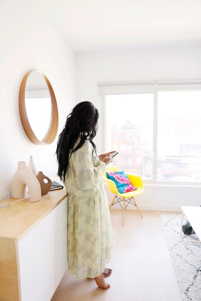 Marie Kouadio Amouzame on phone in bedroom.