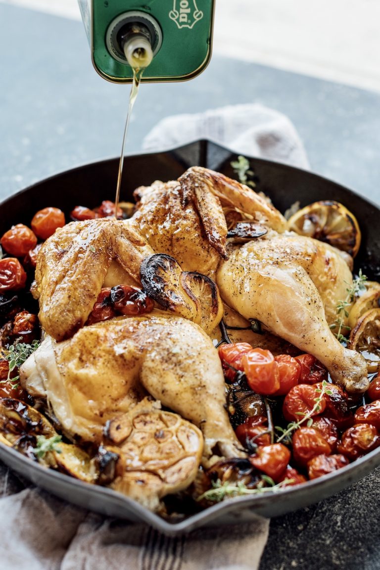 Pour olive oil over roast chicken with cherry tomatoes