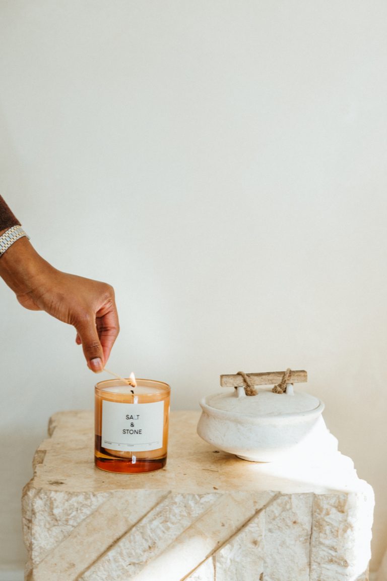 Lighting salt and stone candle on nightstand.