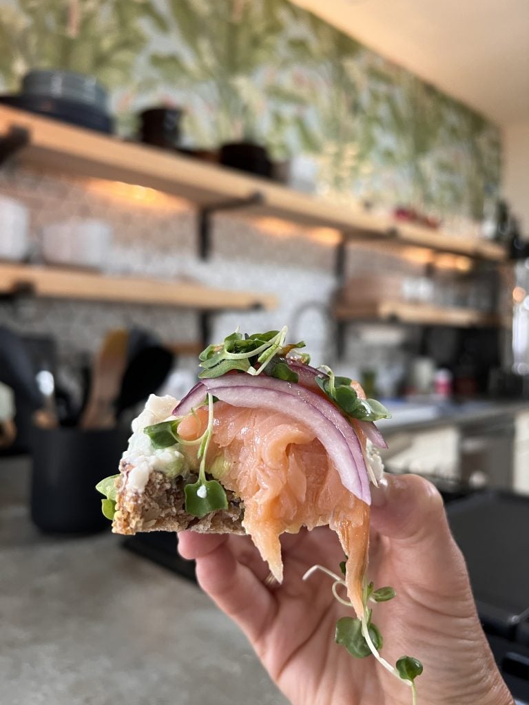 Toast topped with cottage cheese, smoked salmon, greens, and red onion.