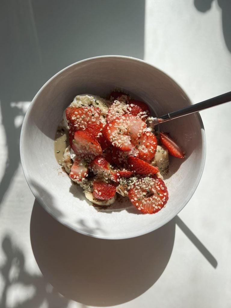 Greek yogurt bowl with strawberries, honey and granola.