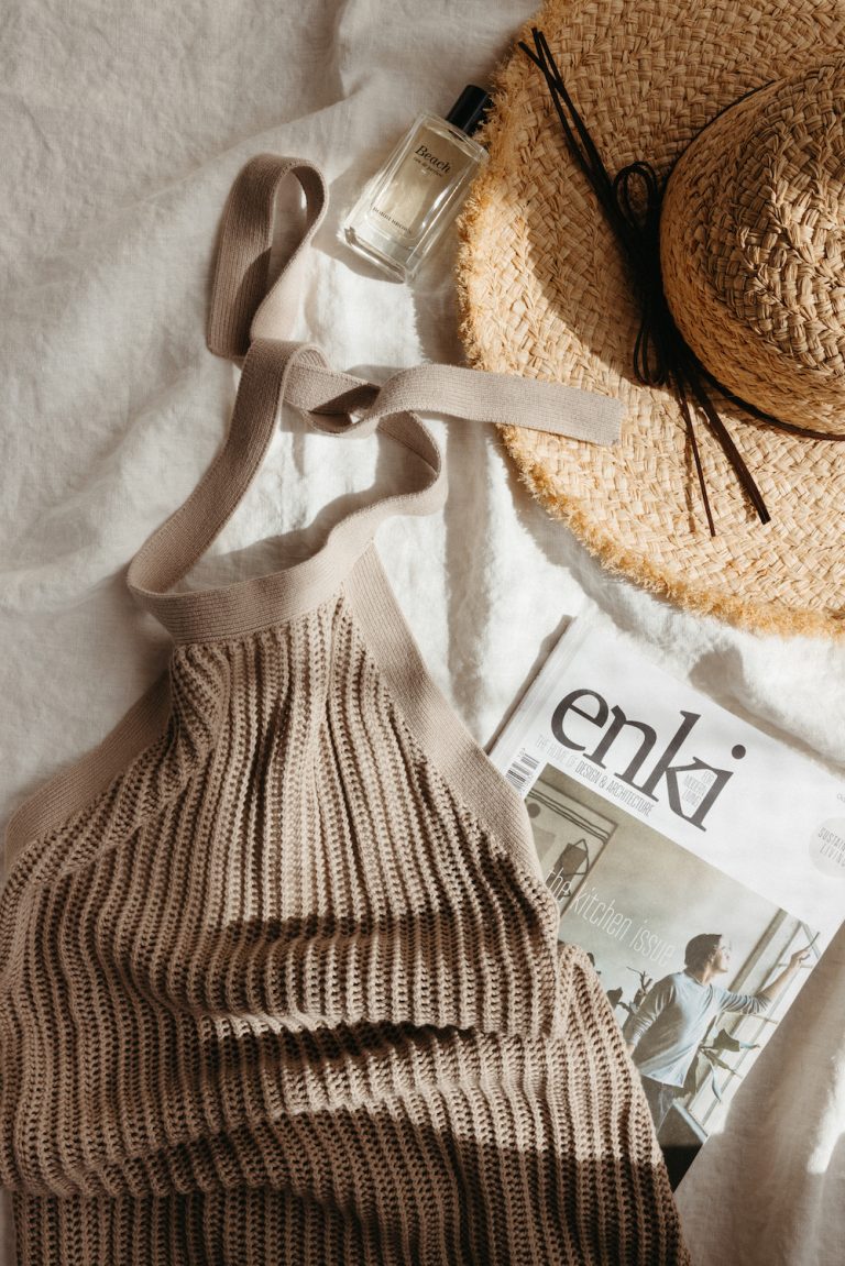 Summer clothing laid out on white bedsheets.