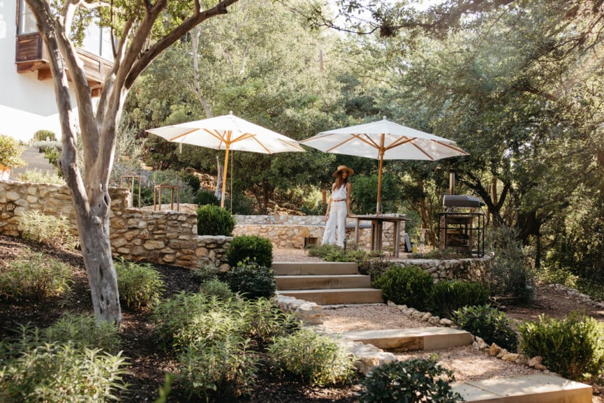 terraced backyard with white umbrellas and gravel pathways