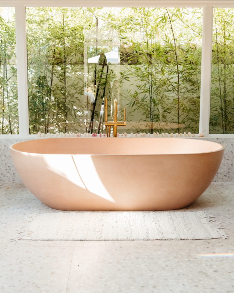 Terracotta-colored bathtub in modern bathroom.