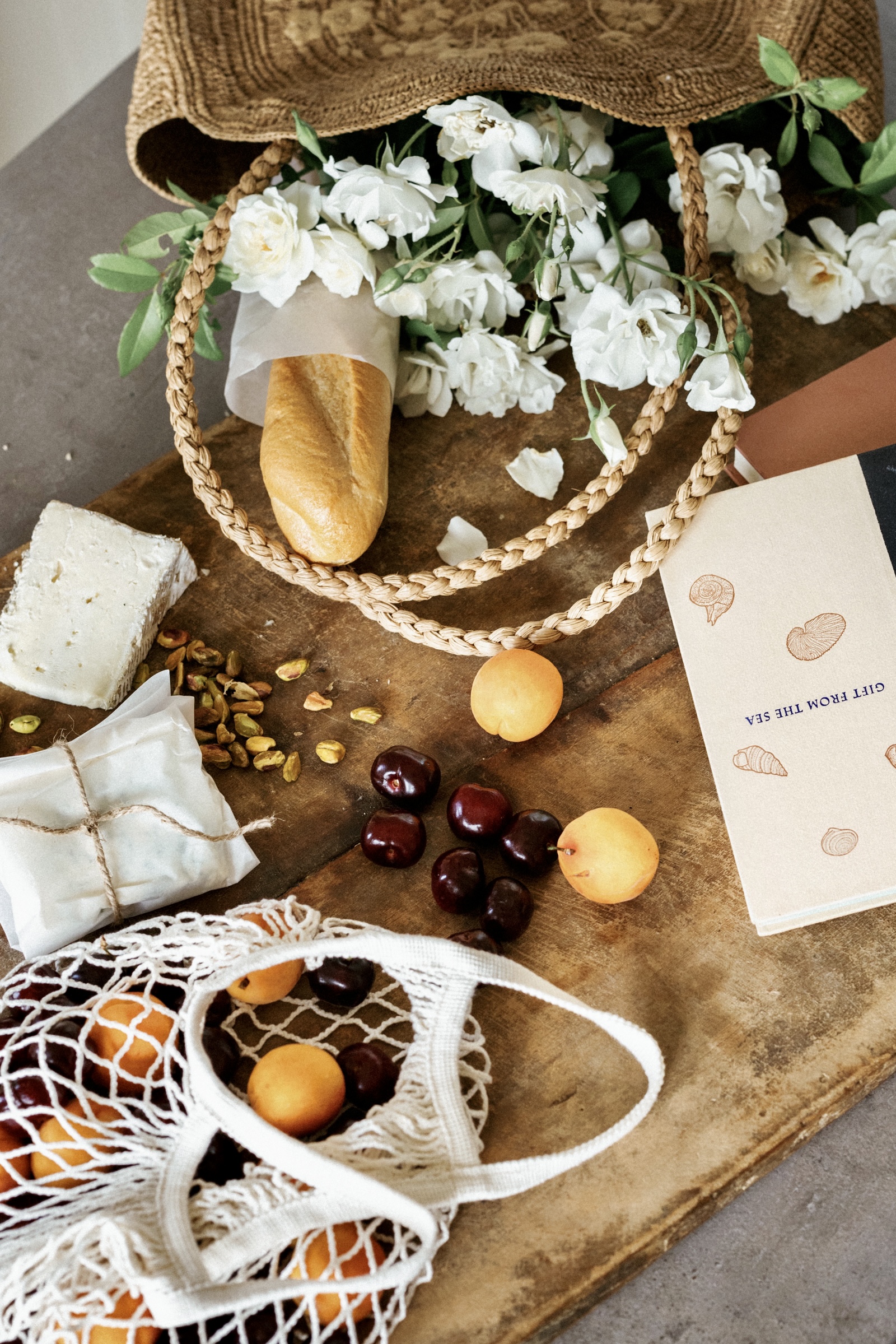 what to pack for an aesthetic picnic — board with baguette, stone fruit, cheese, and book