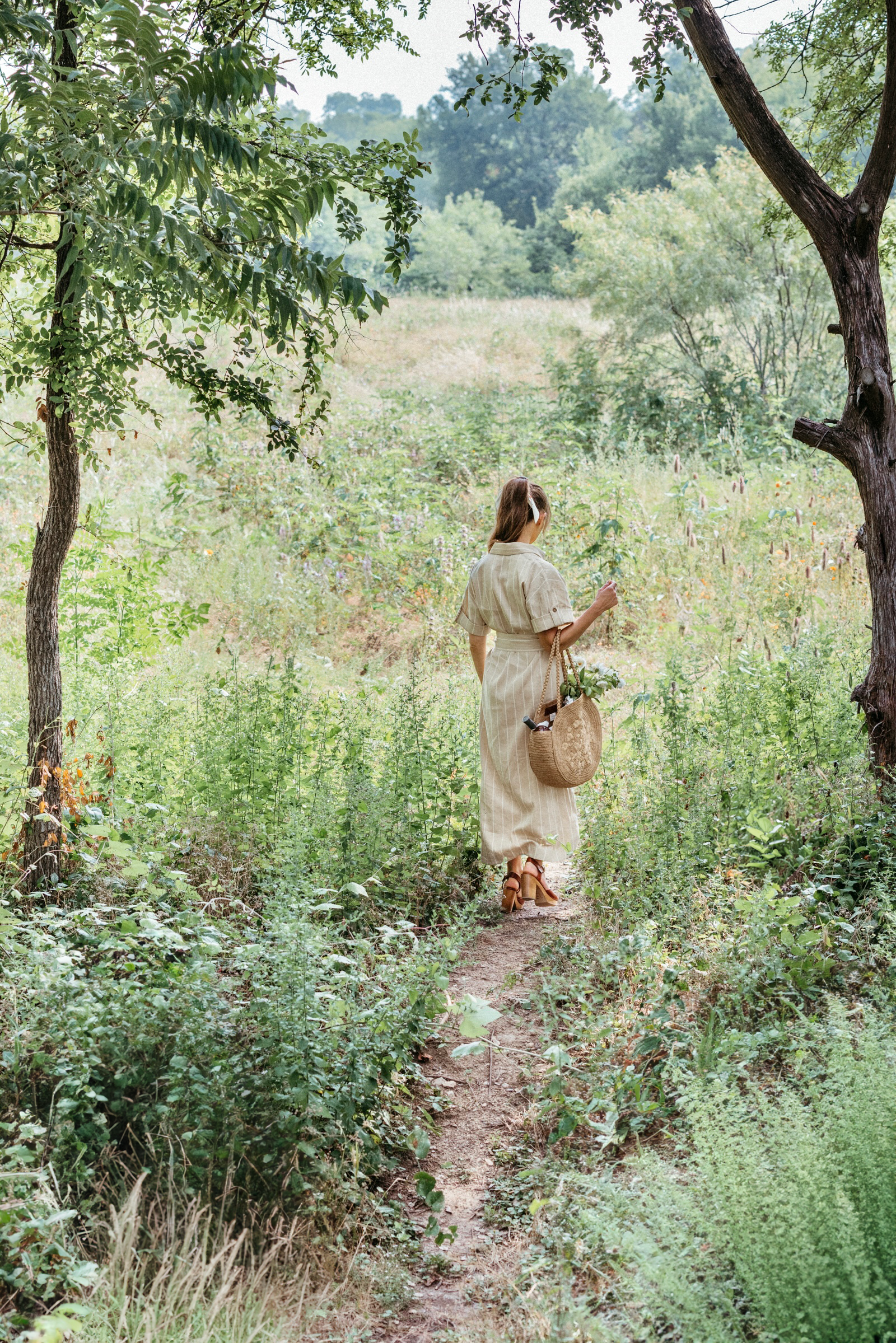 woman walking through field of wildflowers