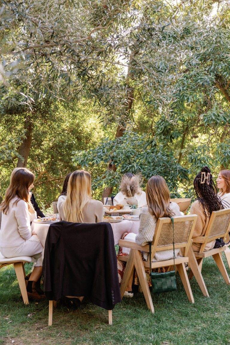 Women eating at an outdoor dining table.